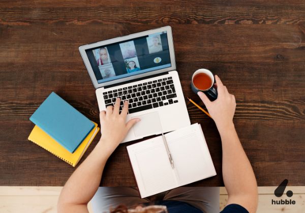 Person attending a virtual meeting on a laptop, representing virtual and hybrid events in corporate culture.