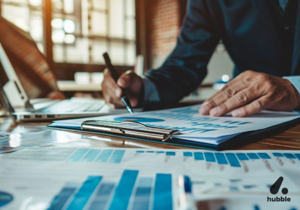 Business professional analyzing sales performance charts and metrics on a clipboard, representing key sales measurement strategies.