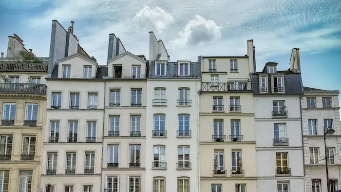 Façades d'immeubles à Paris avec des fenêtres et balcons typiques.