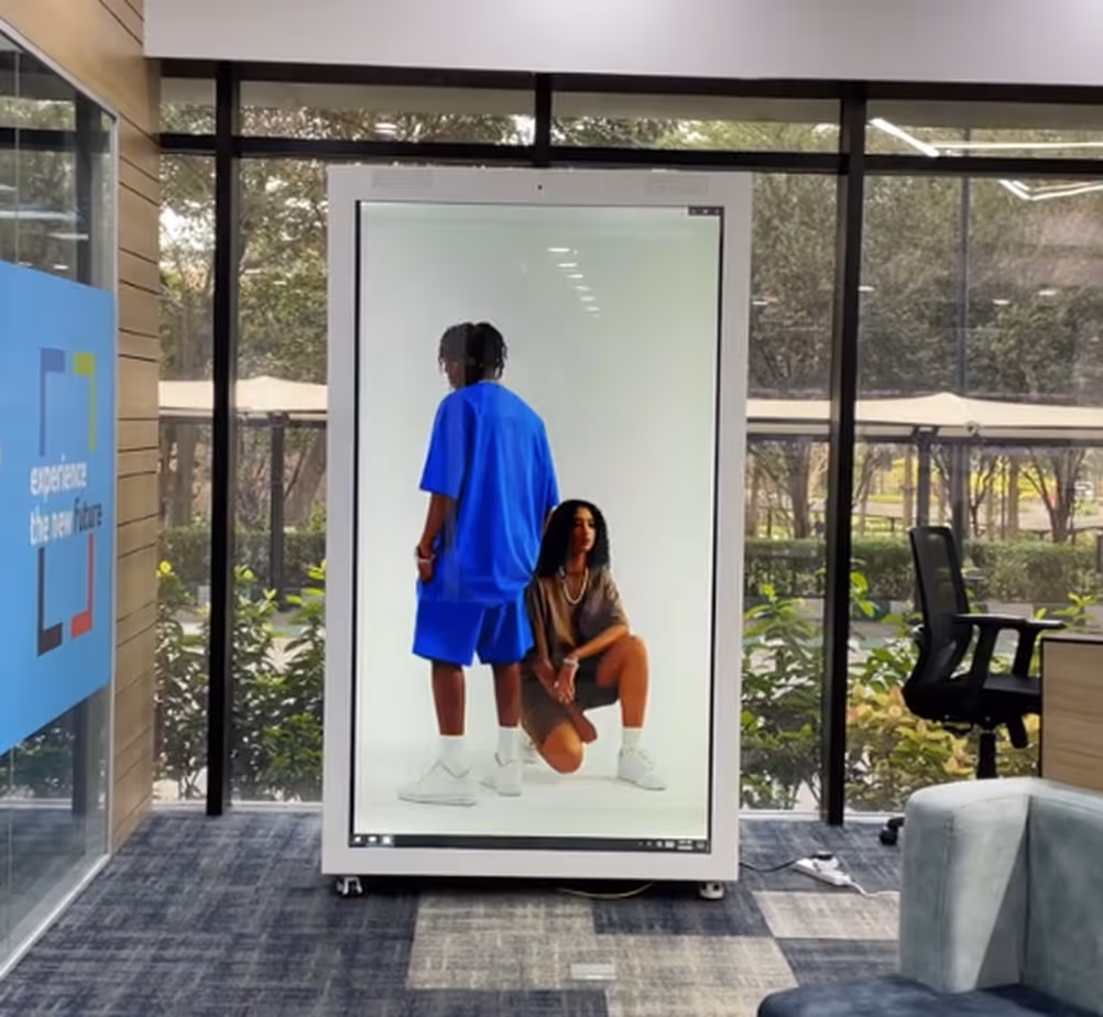 Life-size fashion hologram on a HoloBox911 display in an office atrium walkway, signage placement, India