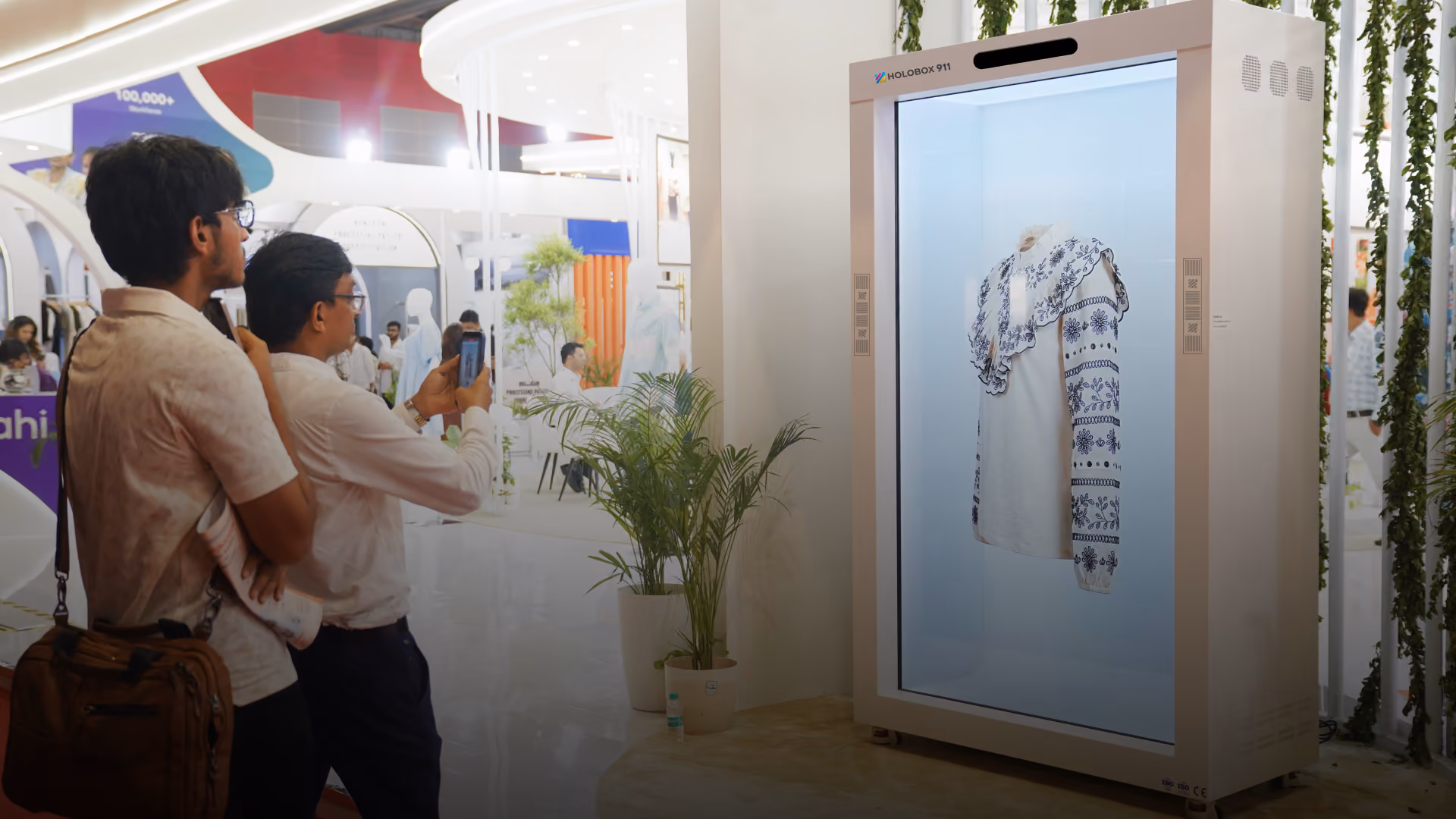 HoloBox911 displaying a 3D garment hologram at an exhibition with visitors
