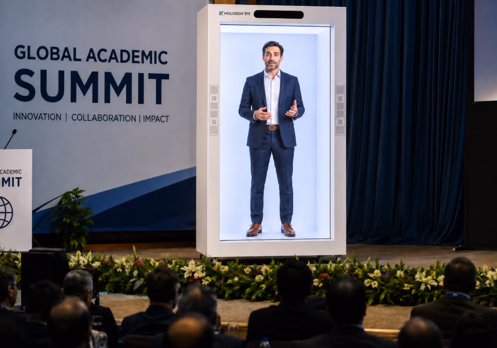 Life-size holographic executive speaking to an audience through a HoloBox display