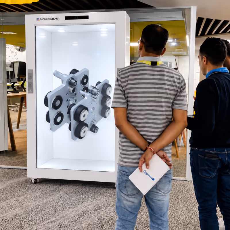 Visitors viewing a 3D mechanical product hologram on HoloBox911 at Capgemini