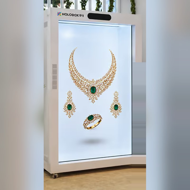 HoloBox911 transparent display showing a diamond and emerald necklace, earrings and ring presented as 3D jewellery content