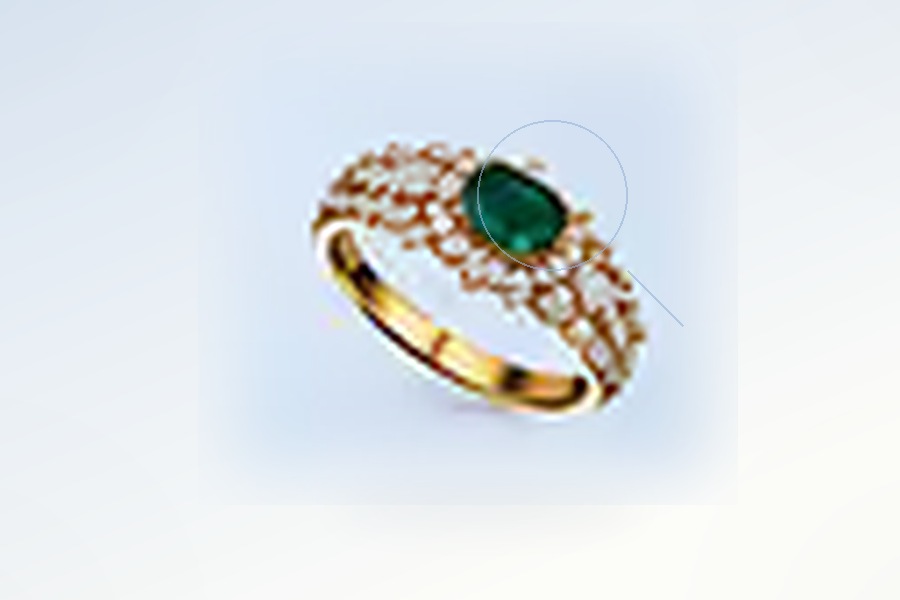 Concept visual: emerald centre stone highlighted at an enlarged visual scale within its setting
