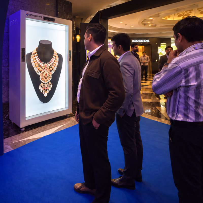 Visitors at a HoloBox911 display showing a layered necklace near the Designer Nook at COUTURE INDIA 2026, New Delhi