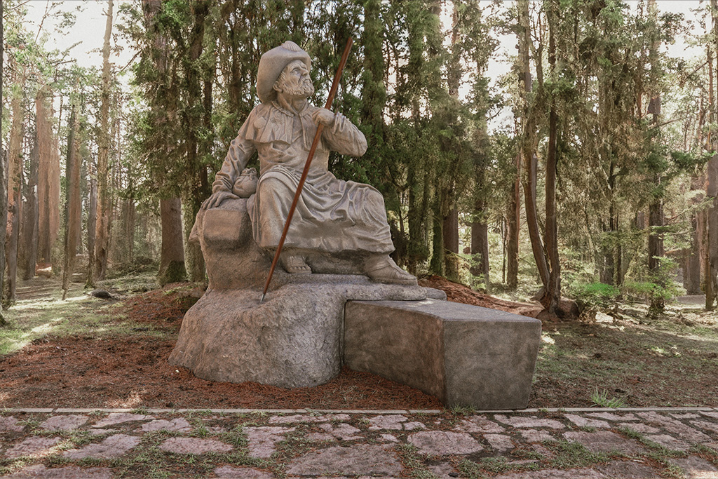 Escultura Banco de Santiago Apóstol para el camino de Santiago entre arboles