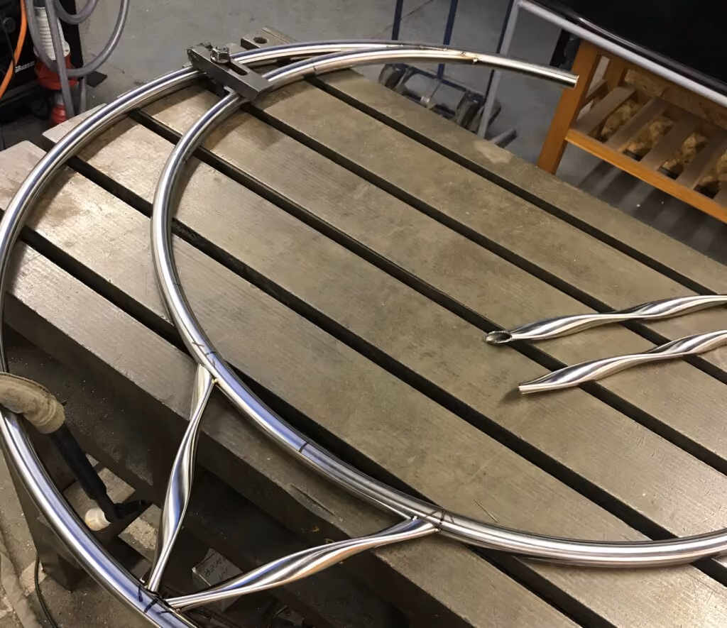 Les tubes ovales tordus décoratifs sont soudés par points à une structure lunaire en acier inoxydable.