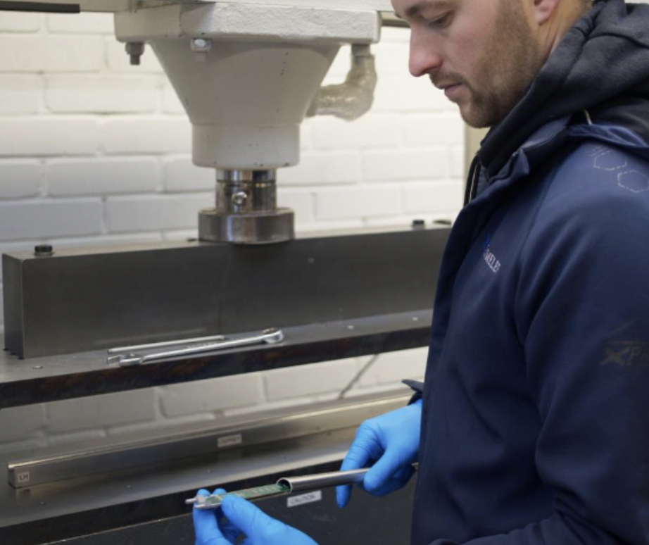 Le médecin Tom McMillan inspecte un tube en forme de D 20x12.5x1.5mm nouvellement formé.