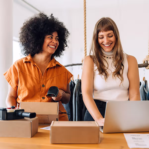 Kaksi iloista myyjää käsittelee tilauksia myymälässä