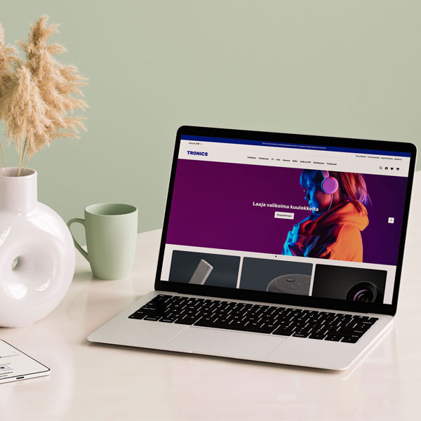 Myymälän tiskillä asiakas on maksamassa ostoksiaan ouhelimen lähimaksulla