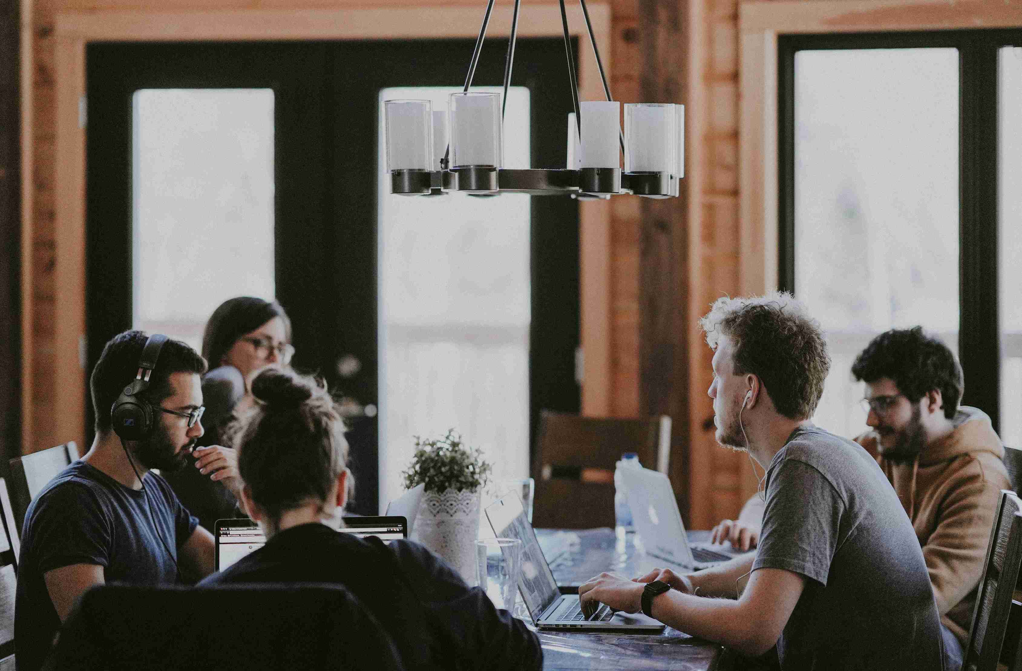 Plusieurs personnes sont assises à une table et travaillent ensemble.