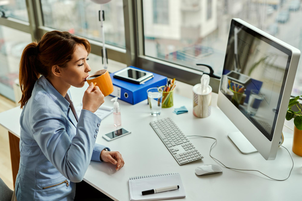 Eine Frau trinkt Kaffee an ihrem Flex Desk.