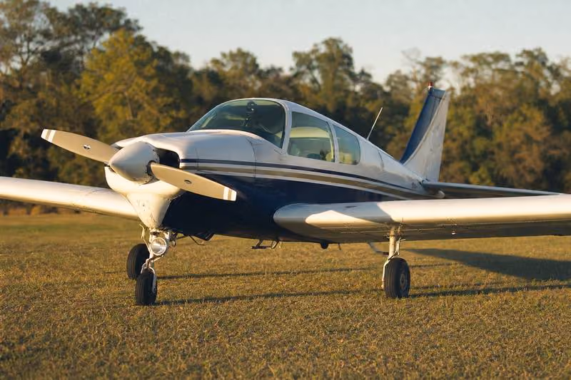Experimental aircraft on grass airstrip at golden hour