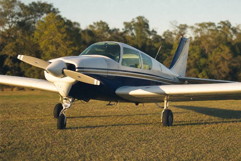 Experimental aircraft on grass airstrip at golden hour