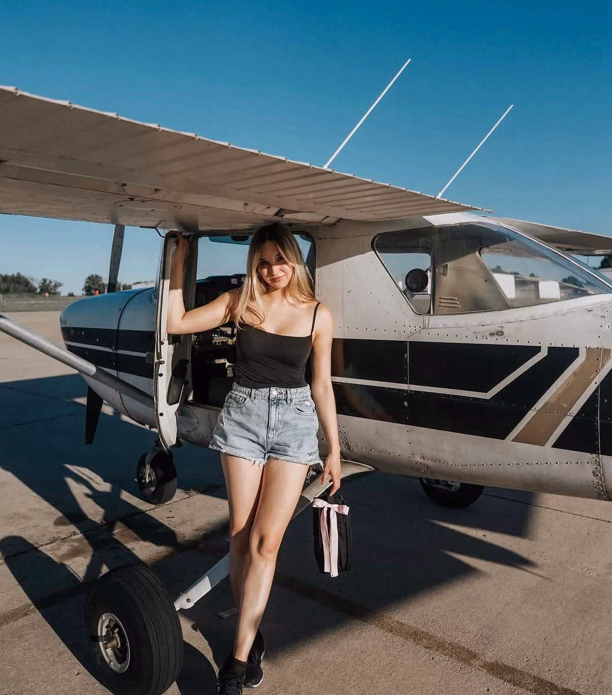 Kel, pilot and SkyWatch brand ambassador, standing next to a small aircraft