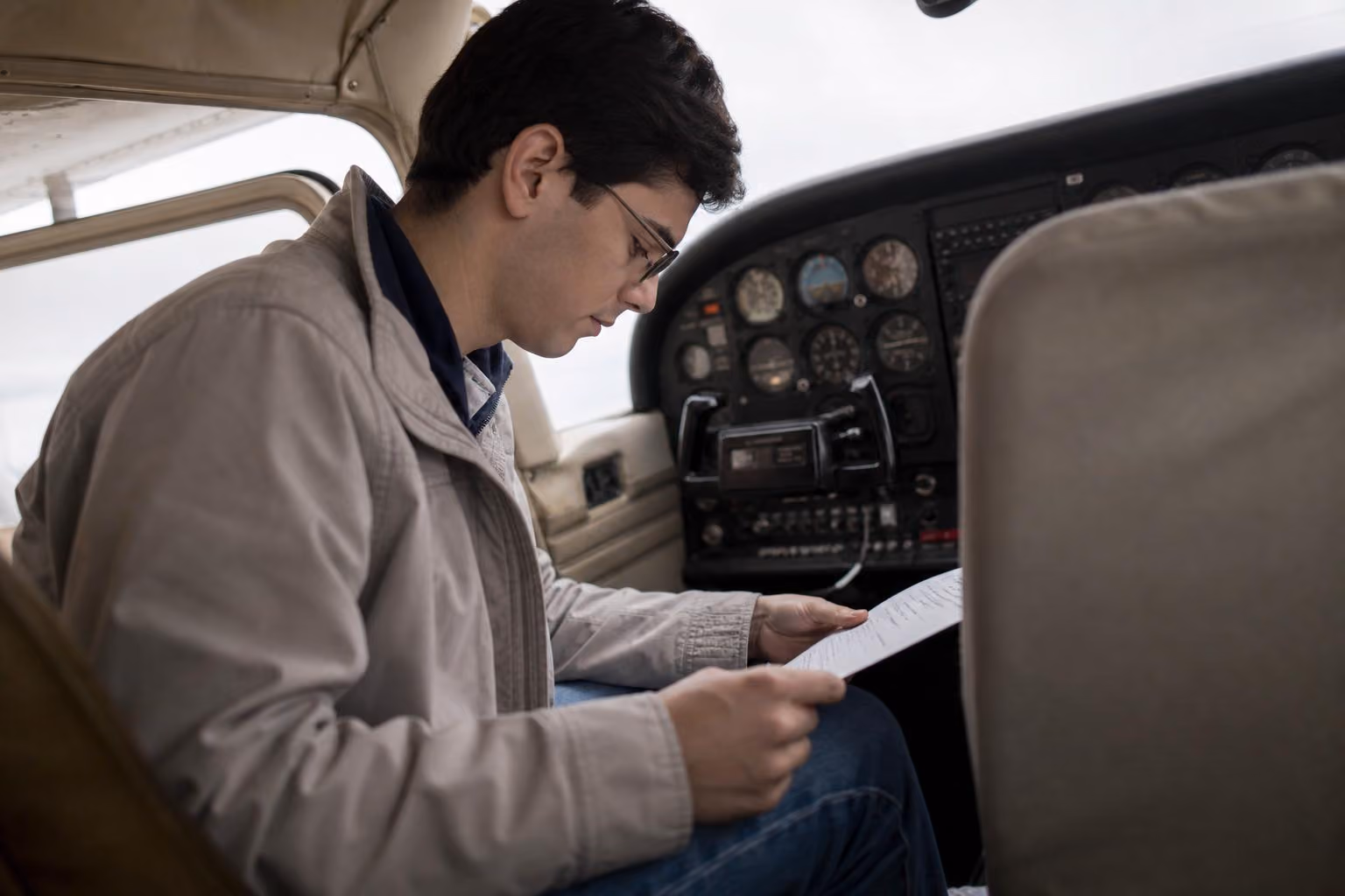 Student pilot reviewing documents in a Cessna 172 cockpit