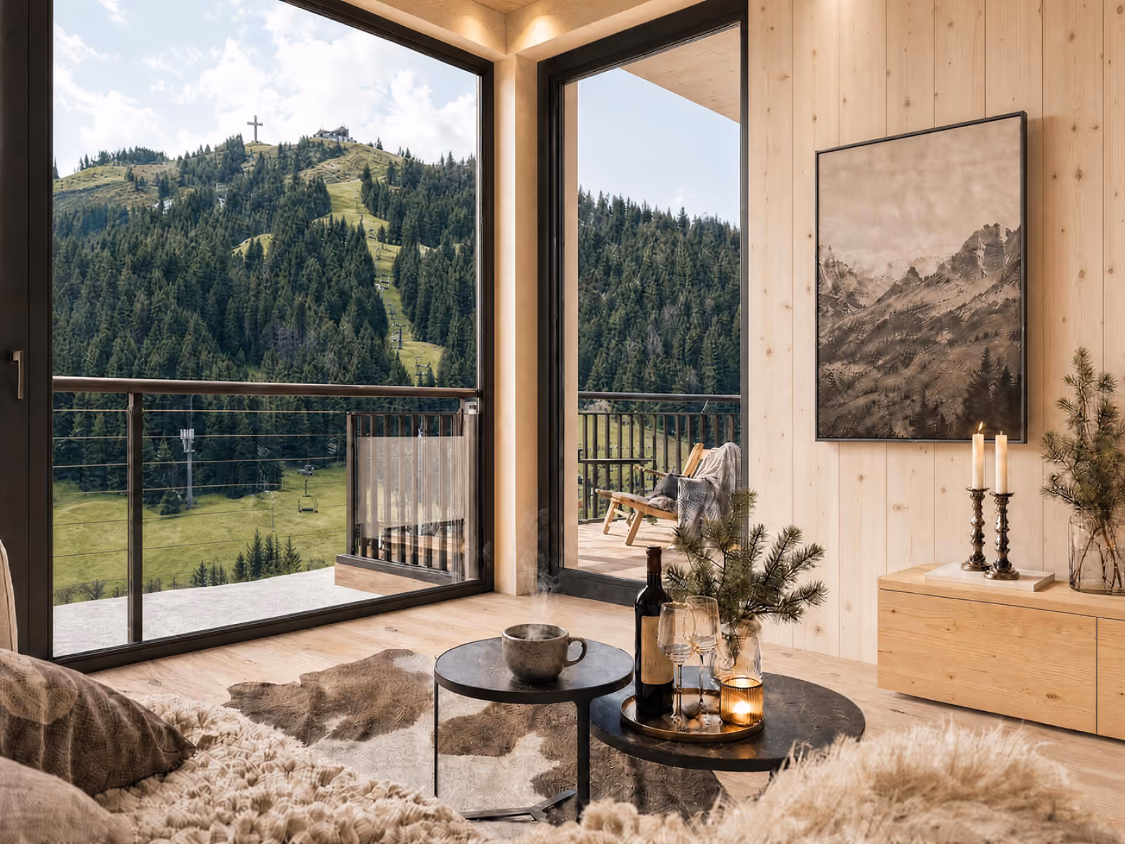 Helles Wohnzimmer mit Massivholzwänden und raumhohen Fenstern – Panoramablick auf das Skigebiet Buchenstein im Sommer