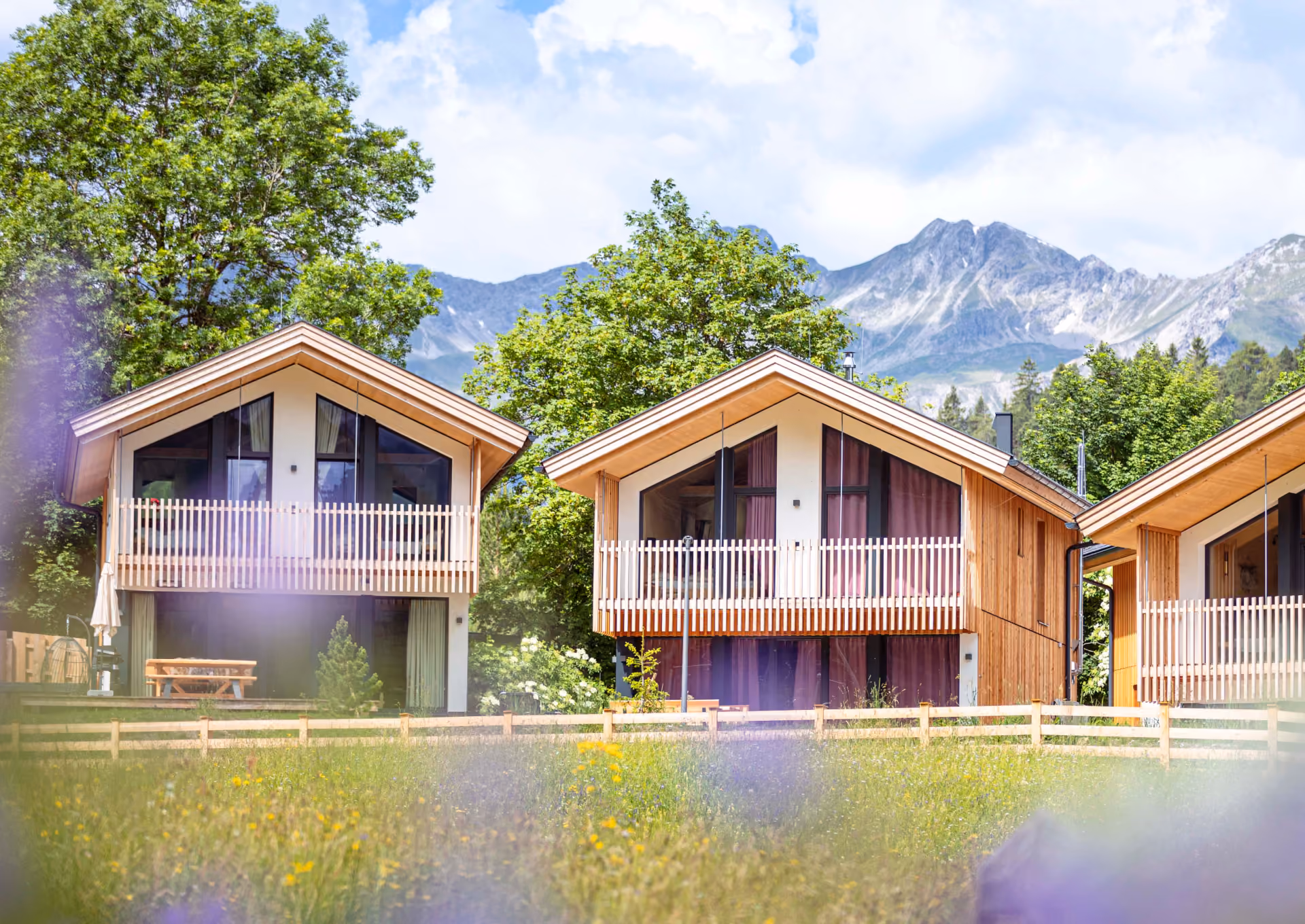 Moderne Holzchalets von ALMDORFBAU mit Balkonen und Bergpanorama – Ferienimmobilien in Österreich kaufen