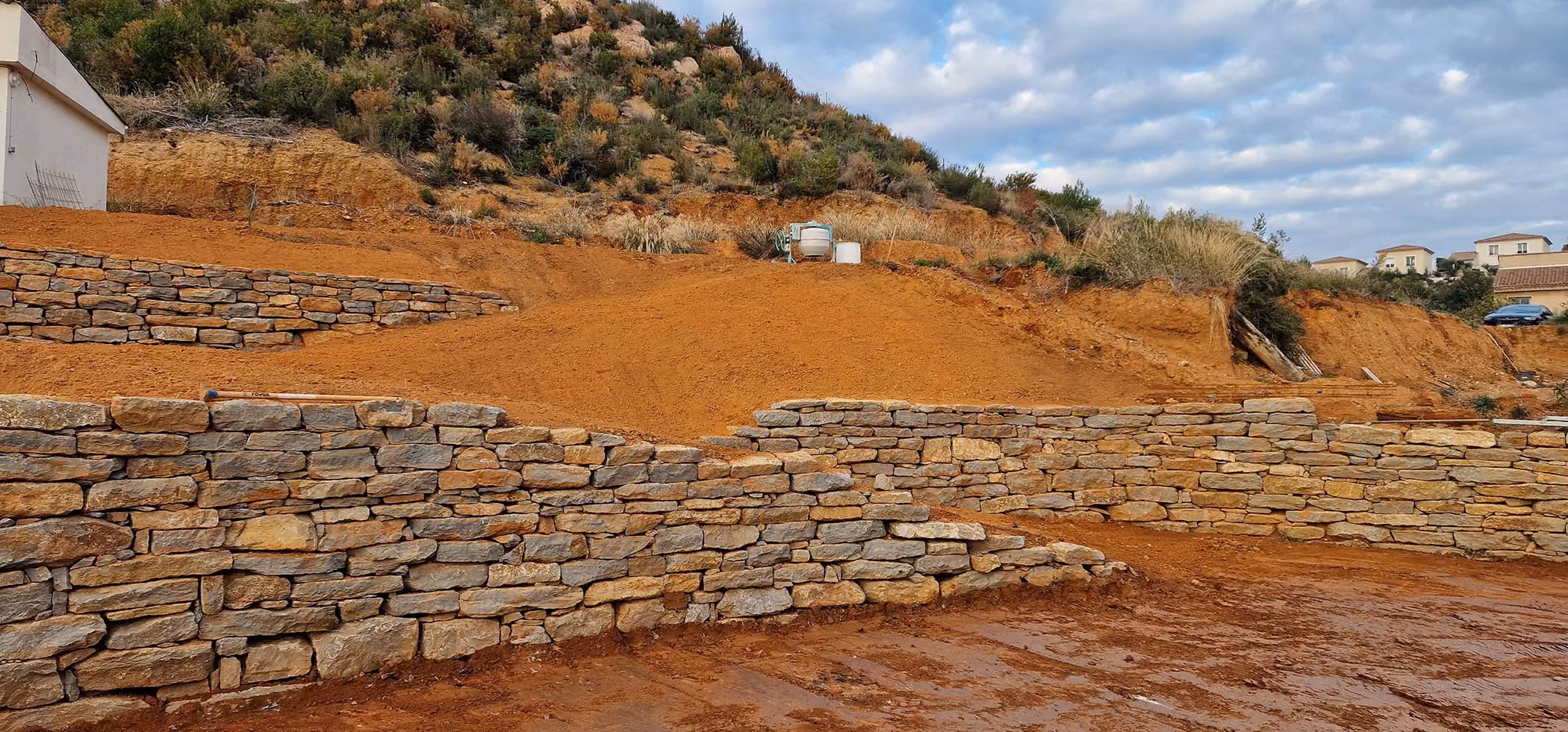 Voici un exemple de mur construit dans le cadre d'une mission d'enrochement pour l'aménagement d'un extérieur par l'entreprise 2CJ Terrassement.