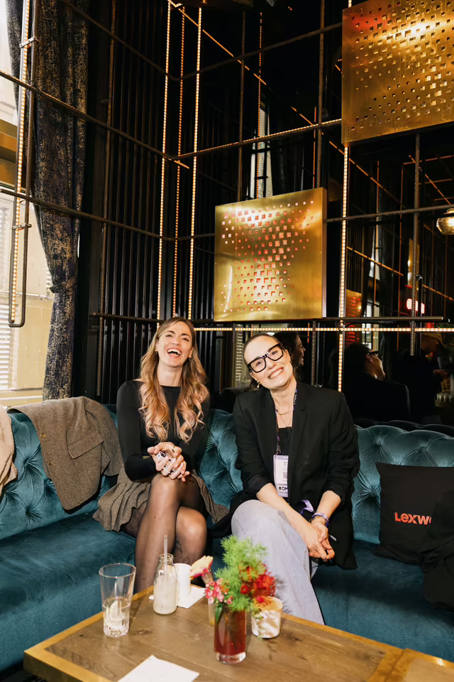 Zwei Gästinnen lachen gemeinsam auf dem Lounge-Sofa beim Lexware Founders Brunch