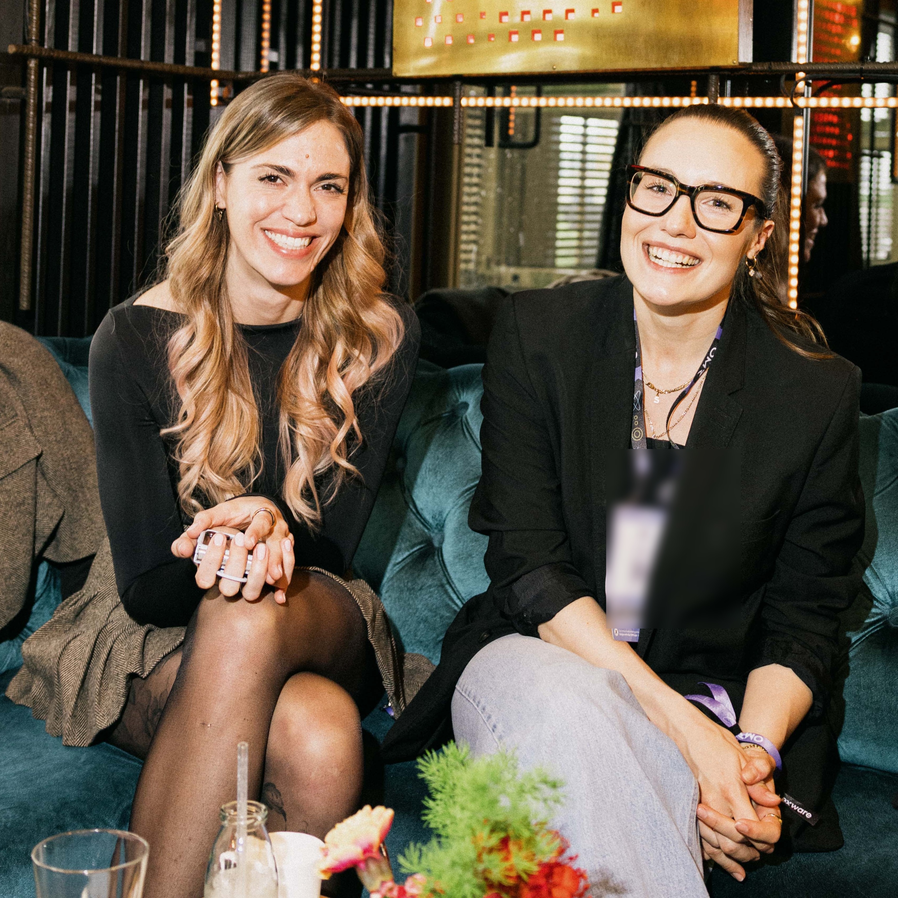 Zwei Gästinnen lachen gemeinsam auf dem Lounge-Sofa beim Lexware Founders Brunch 2026