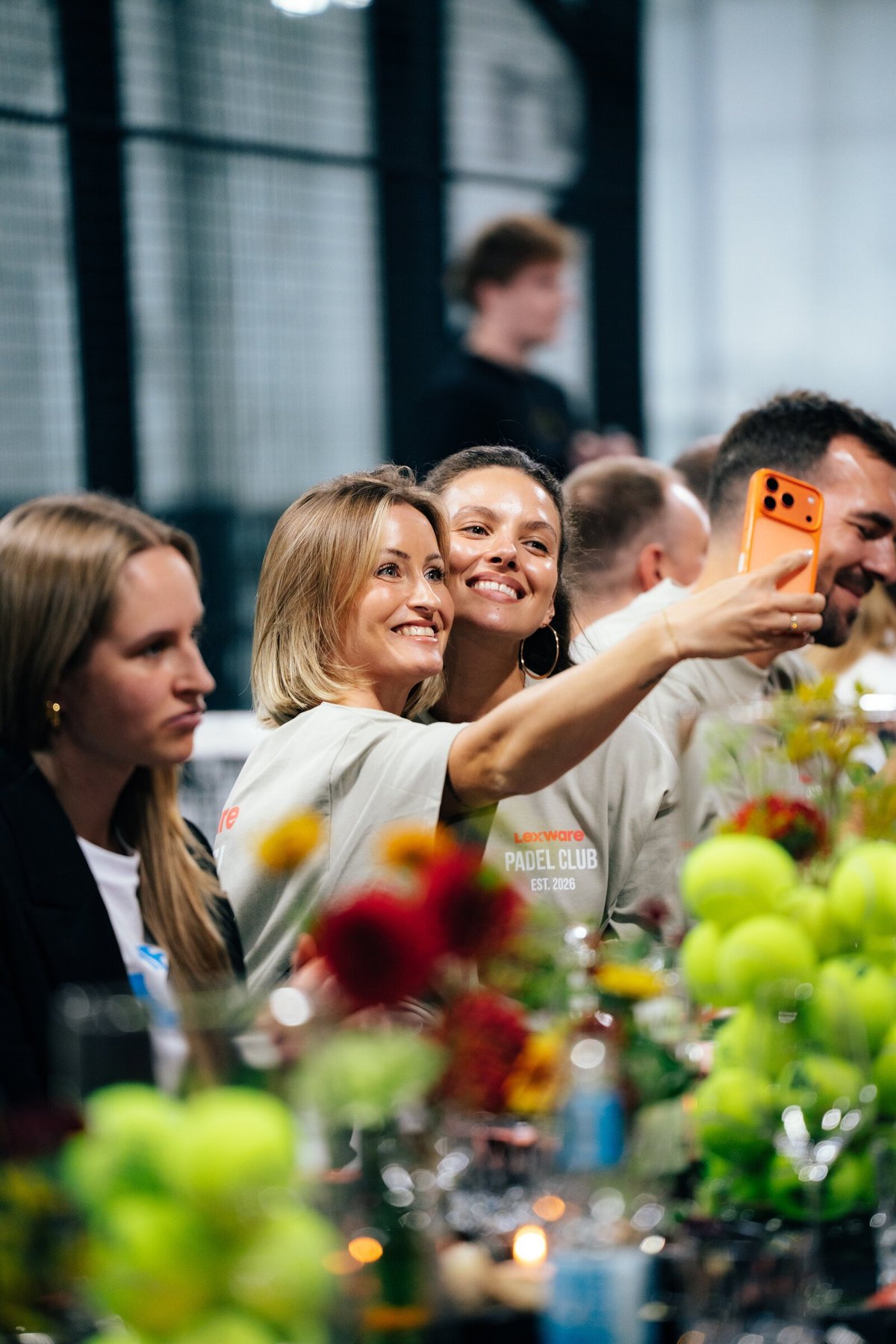 Gäste machen lachend ein Selfie an der Tafel.