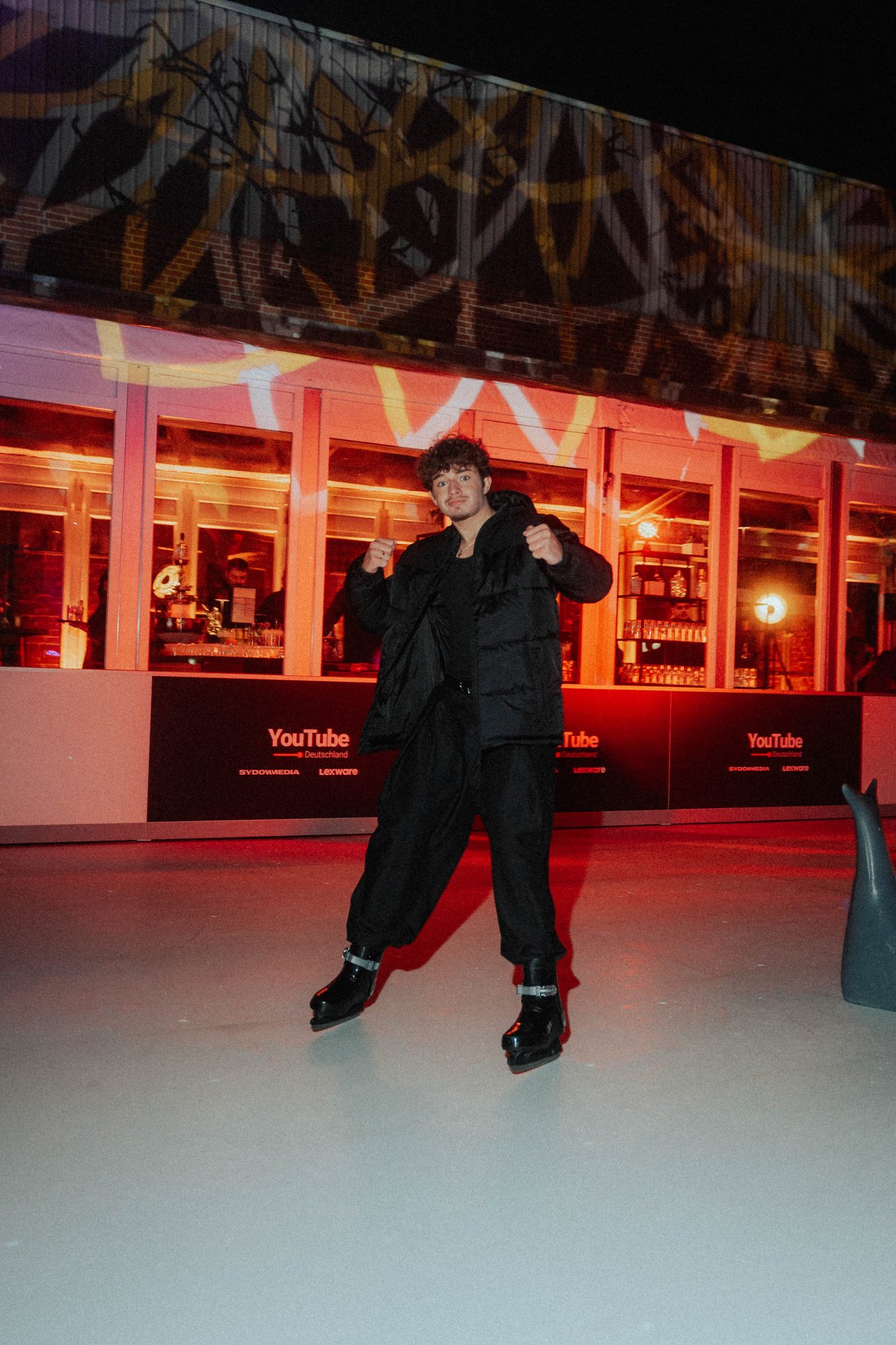Gast läuft Schlittschuh auf der Eisbahn vor der Lounge