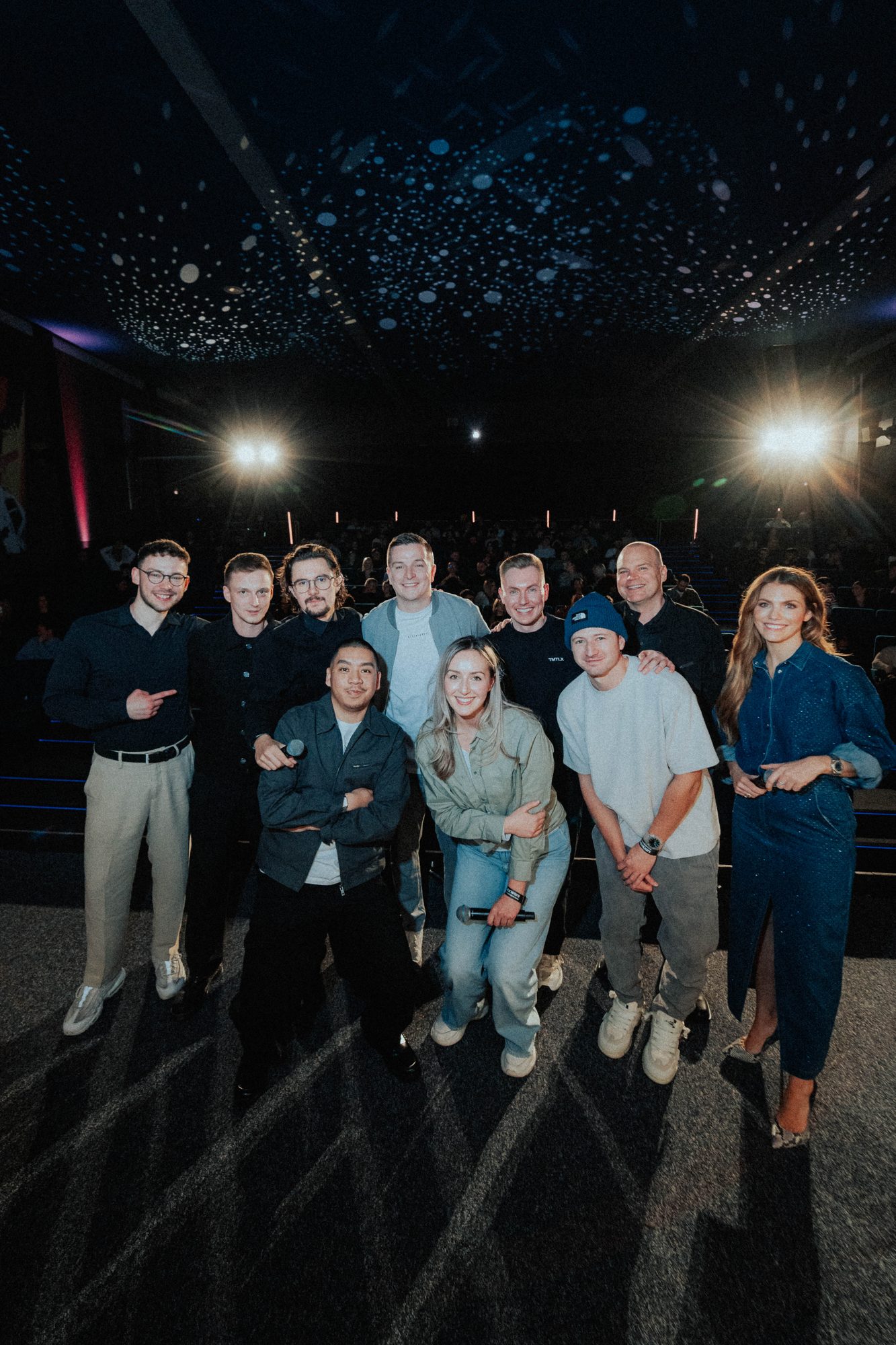 Gruppenfoto auf der Bühne zum Abschluss der Premiere, im Rücken der Saal