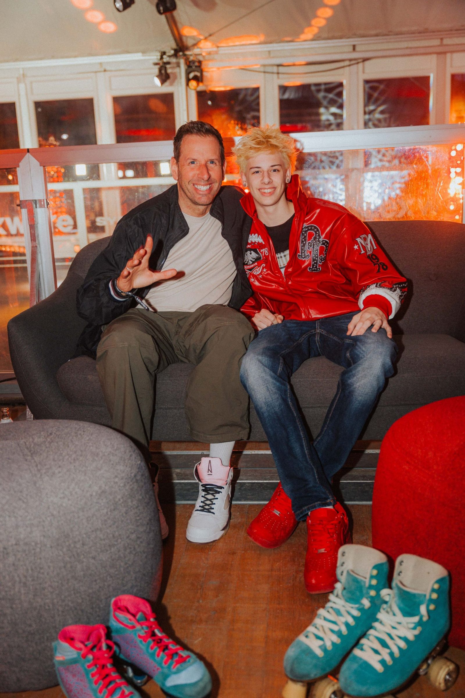 Zwei Gäste sitzen lachend auf dem Sofa der Lounge, davor Rollschuhe