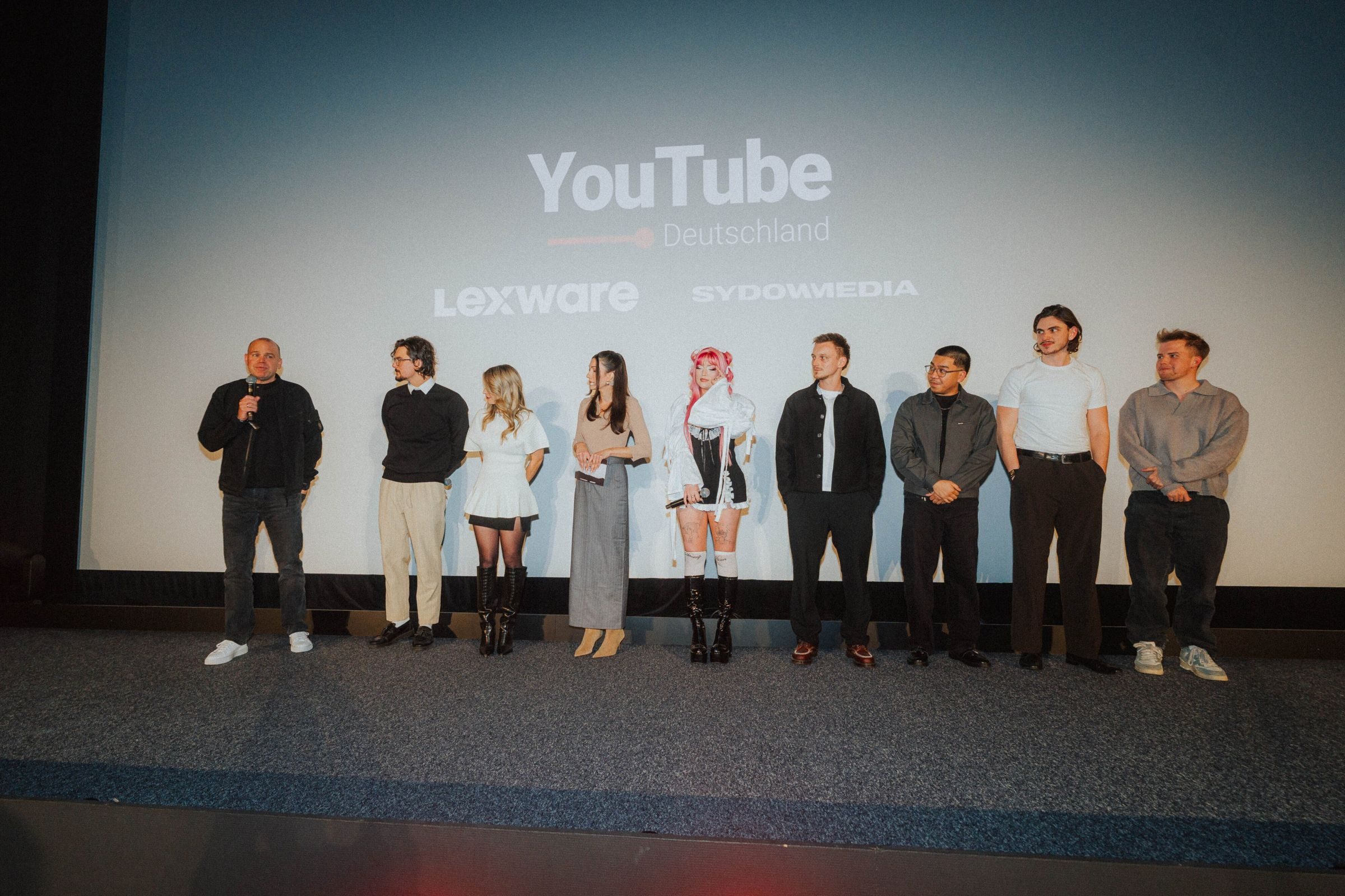 Alle Beteiligten des Abends stehen gemeinsam auf der Bühne vor der Leinwand von YouTube Deutschland