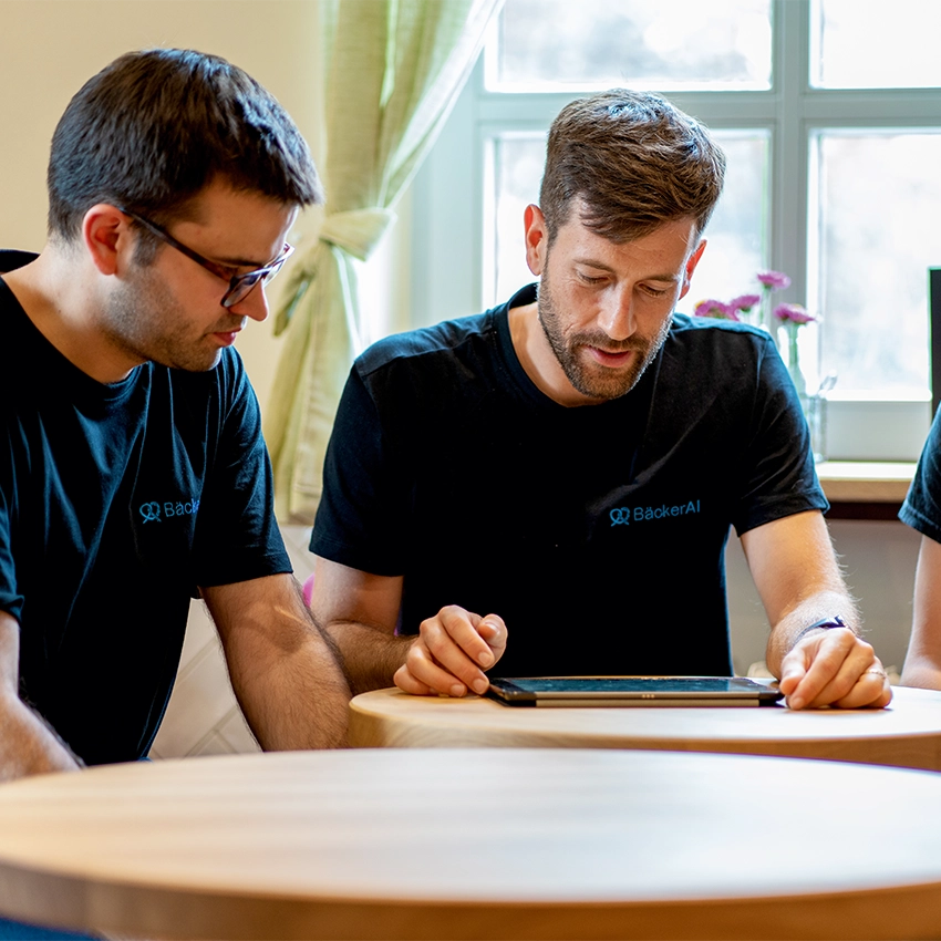 Zwei Gründer des Start-ups PlanerAI am Tisch vor Tablet - Beitragsbild von Lexware Tell Your Story