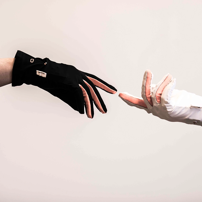 Zwei gegenüberstehende Hände mit intelligenten Handschuhen des Start-ups Cynteract - Beitragsbild von Lexware Tell Your Story
