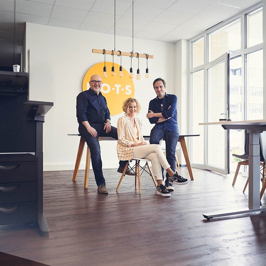 Die drei Gründer der Agentur dots an einem Tisch - Beitragsbild von Lexware Tell Your Story