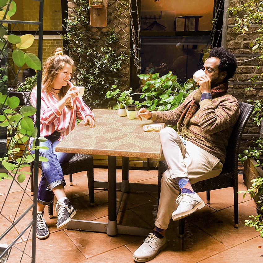 Mann und Frau an einem Gartentisch, die Kaffee trinken - Beitragsbild von Lexware Tell Your Story