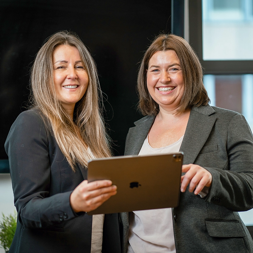 Die beiden Gründerinnen der Online-Plattform Querwerk vor Tablet - Beitragsbild von Lexware Tell Your Story