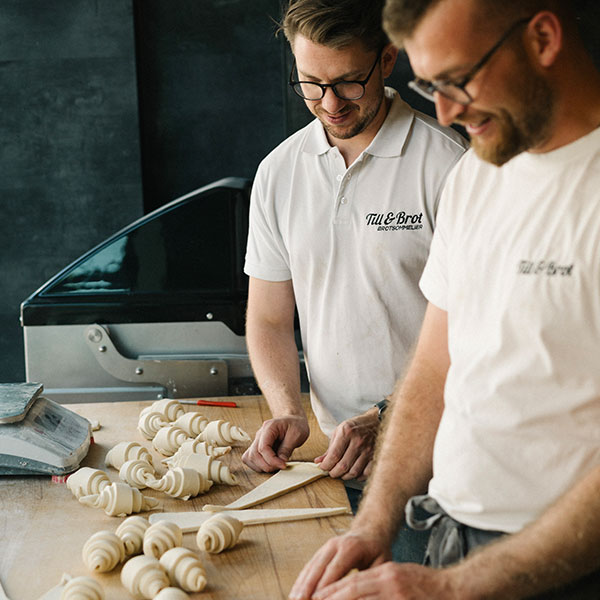 Bäckermeister Till Gurka von Till & Brot bereitet mit einem Bäckerkollege ein Croissant zu
