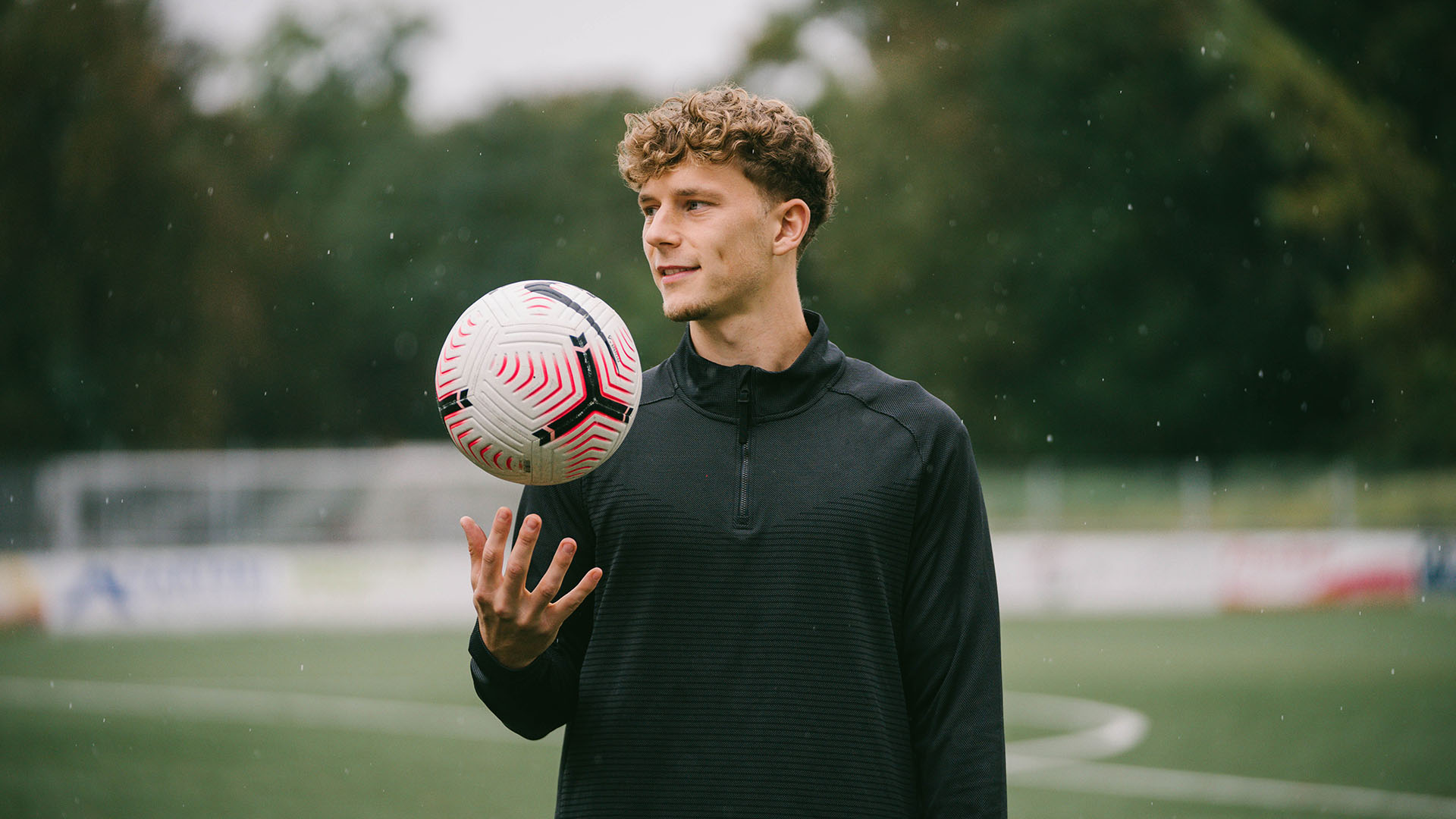 Yannik Keitel wirft einen Fußball mit einer Hand in die Höhe.