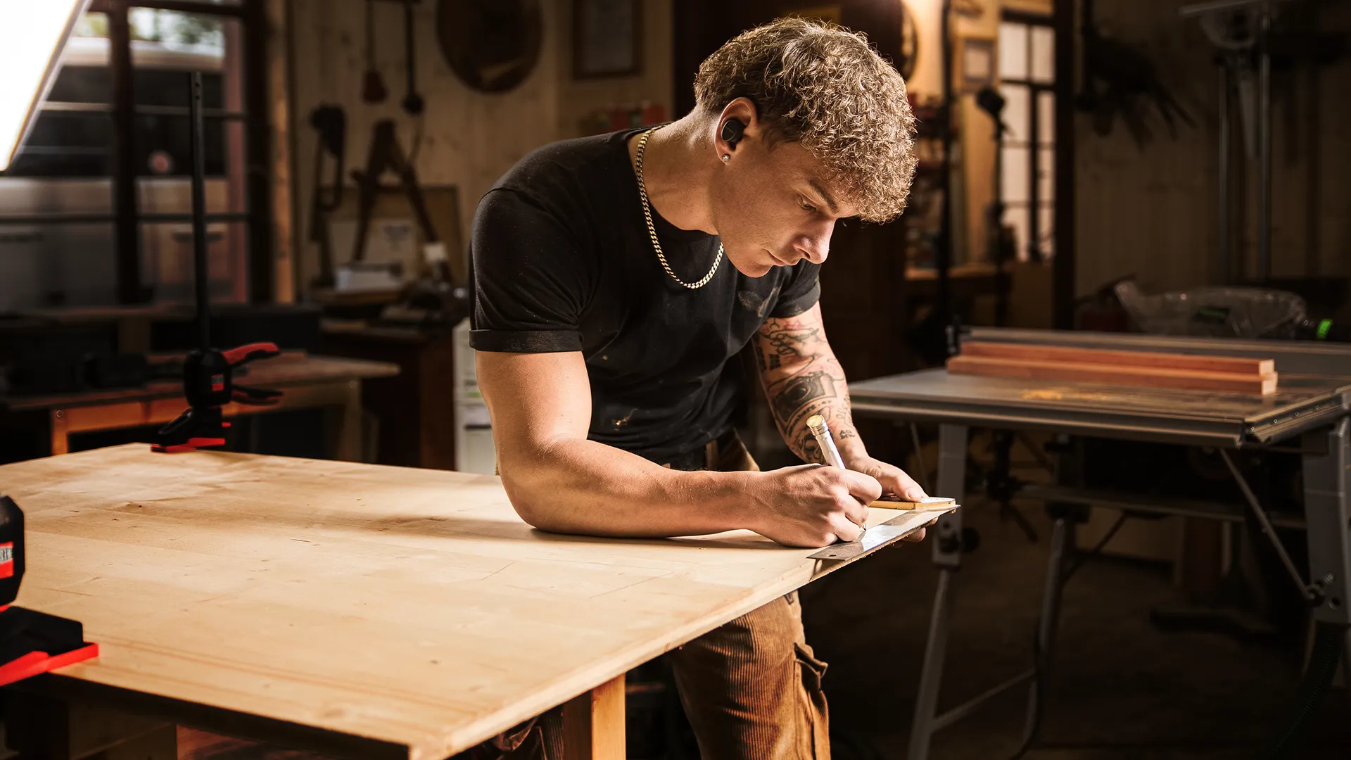 Handwerker Ben Berger beim Abmessen einer Holzplatte
