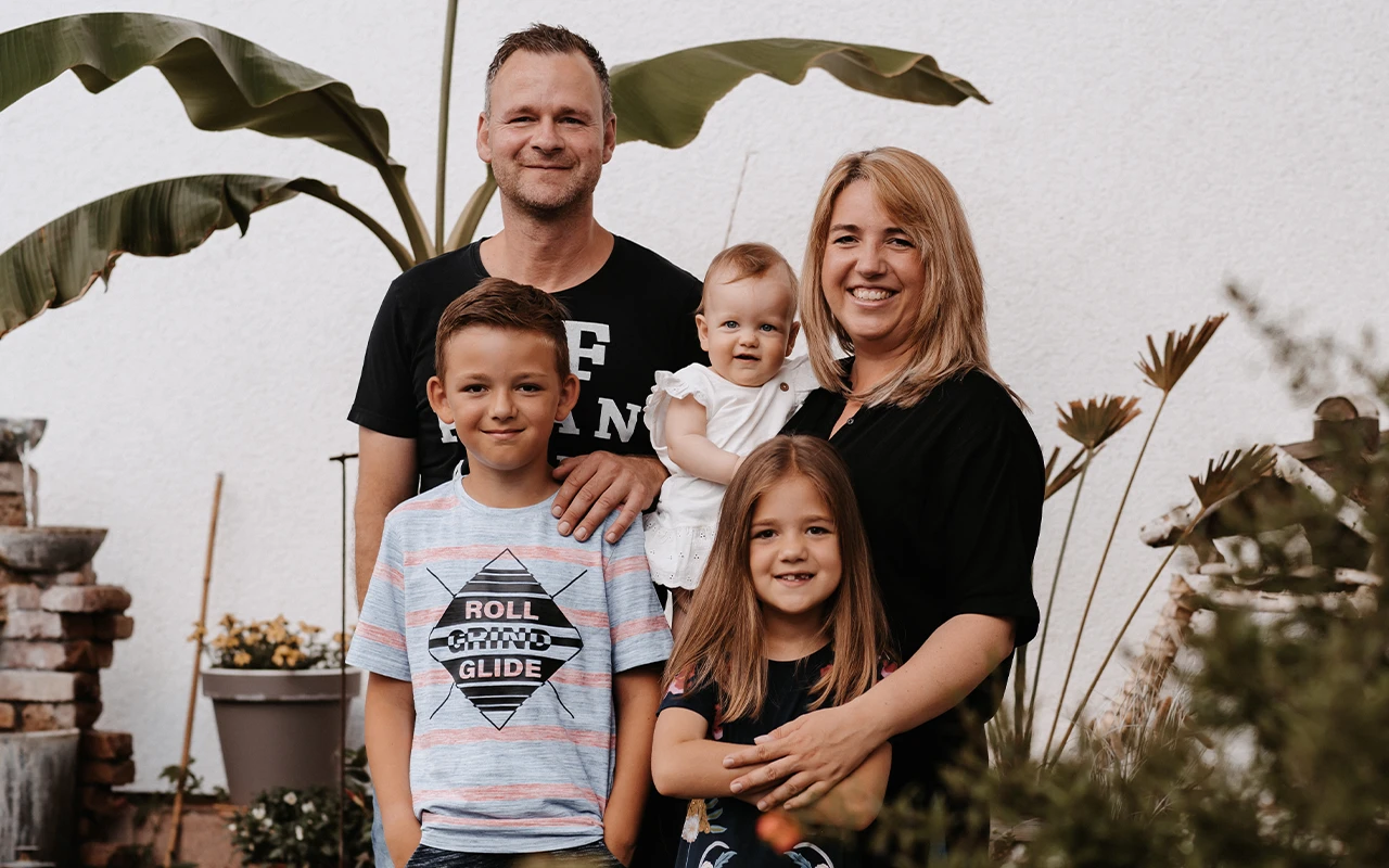 Mutter, Vater und drei Kinder stehen im Garten - Beitragsbild von Lexware Tell Your Story