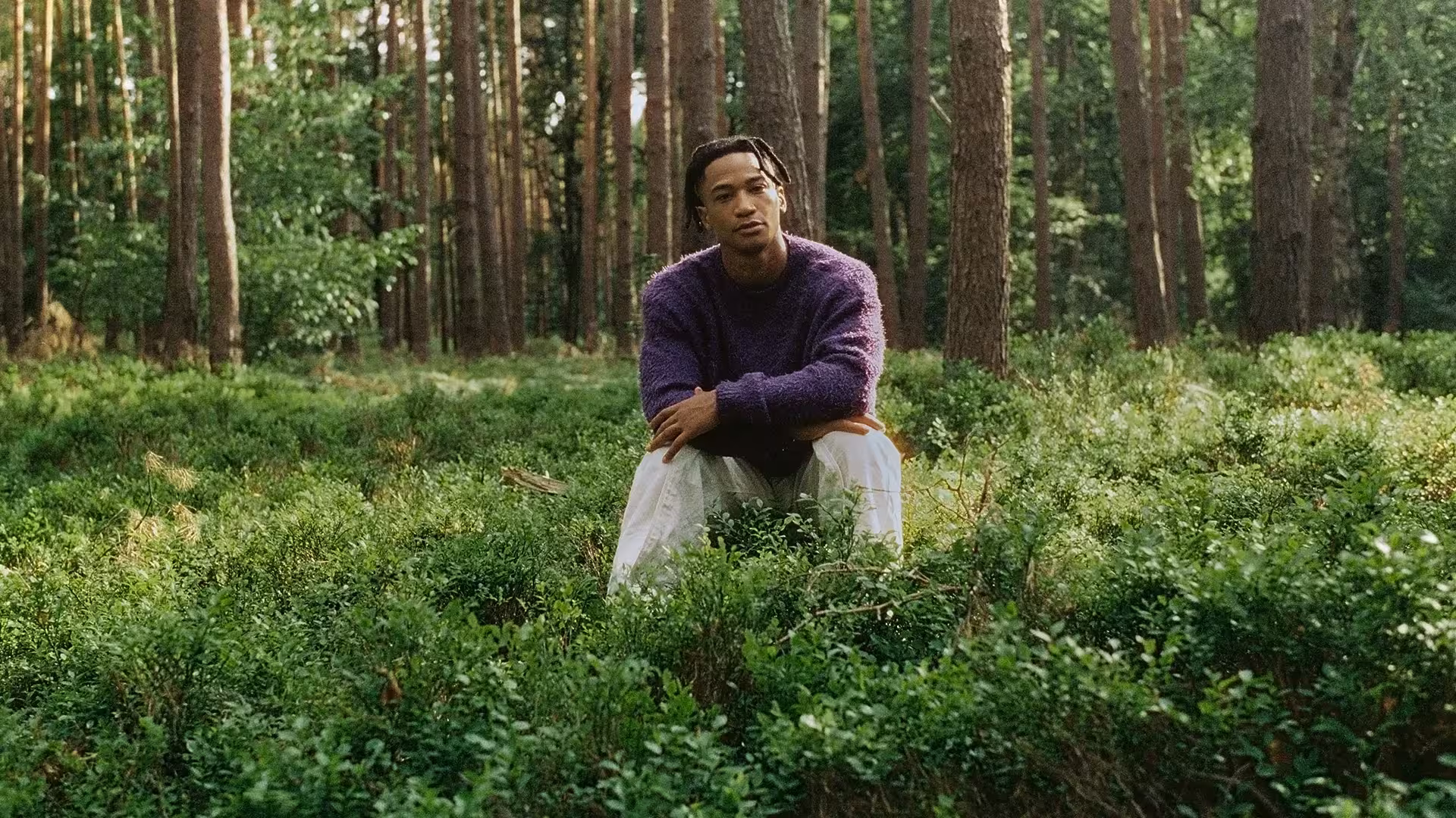 Daniel Hernandez sitzt im Wald auf dem Boden.
