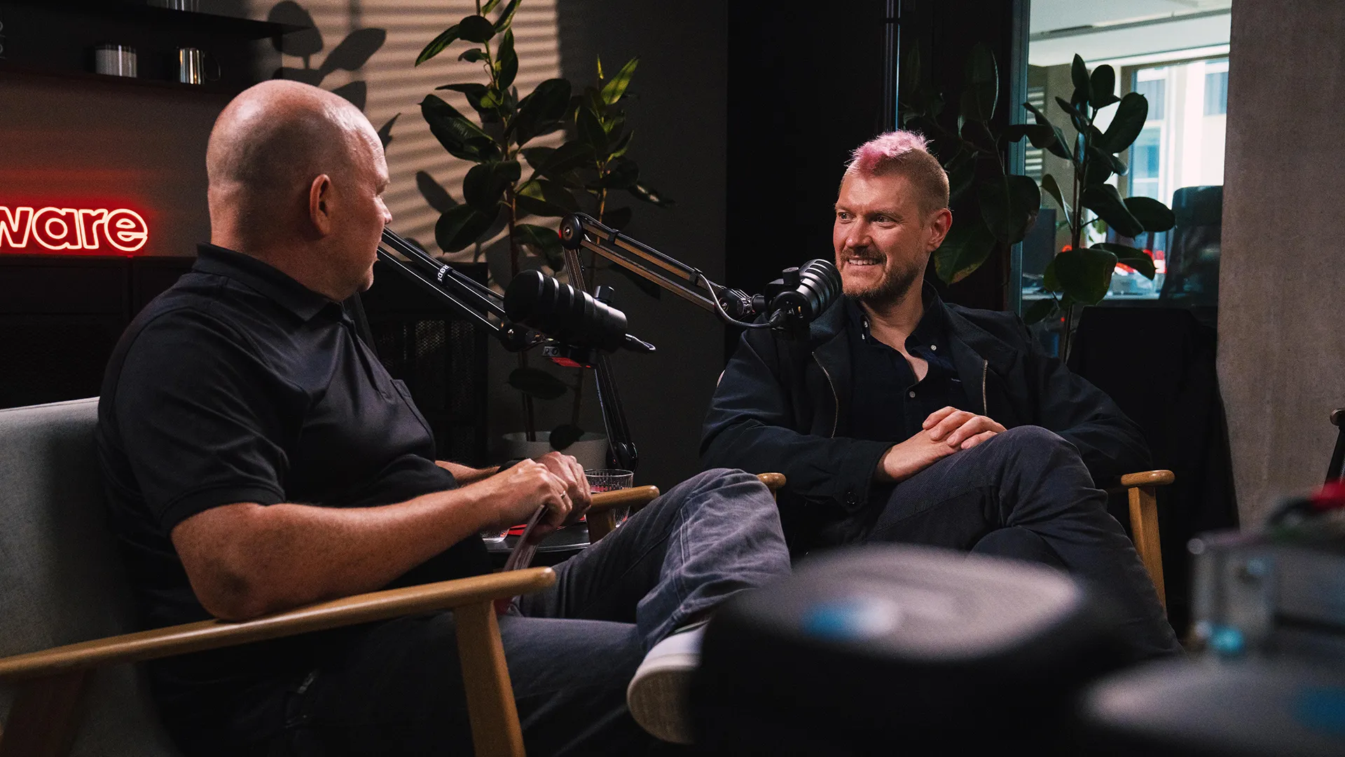 Christian Steiger und Sascha Lobo sitzen und sprechen in Mikrofone in einem gemütlichen Podcast-Studio mit Pflanzen im Hintergrund.