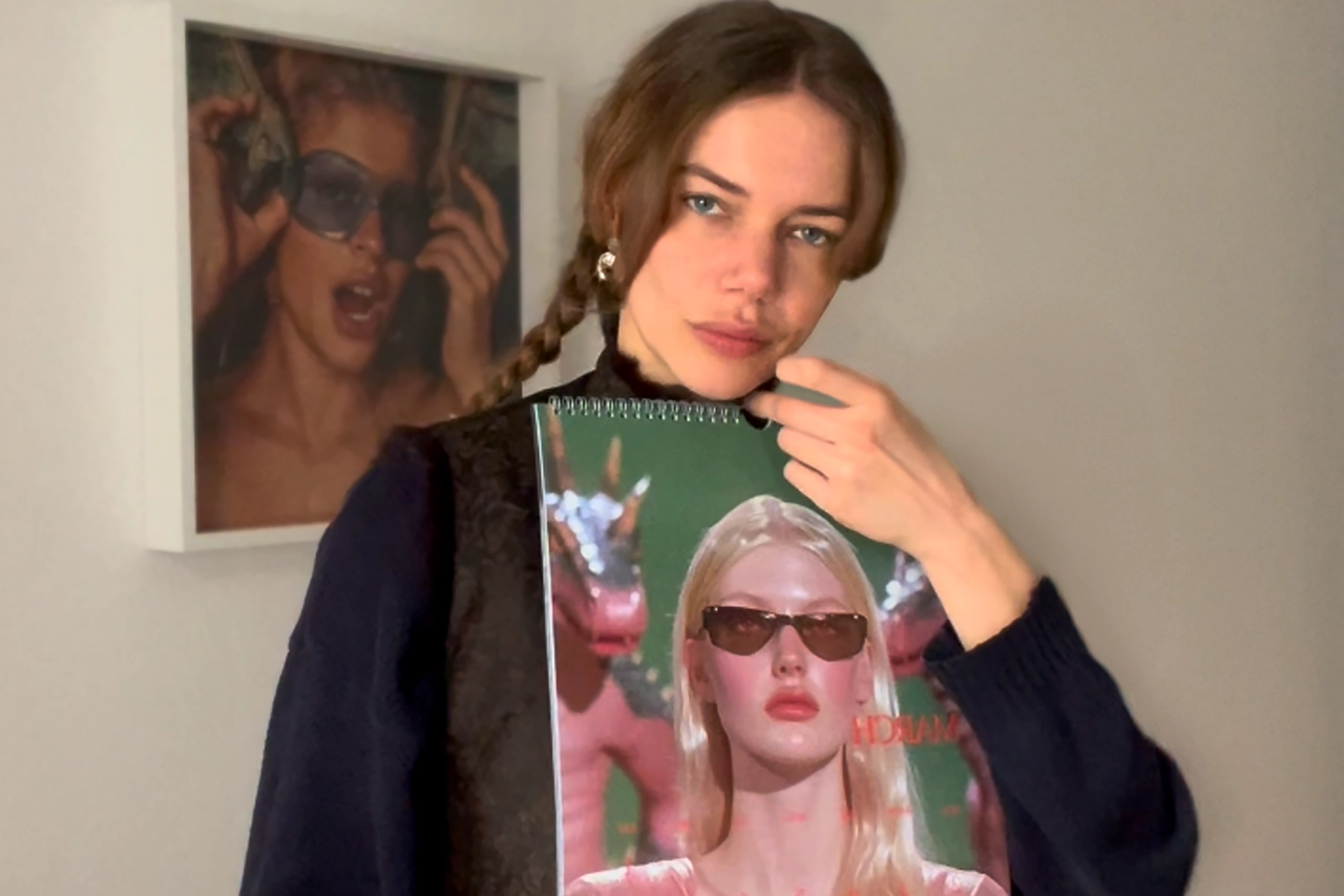 Lilly Zumholte mit geflochtenem Haar hält einen Druck einer blonden Frau mit Sonnenbrille und glänzendem rosa Oberteil.