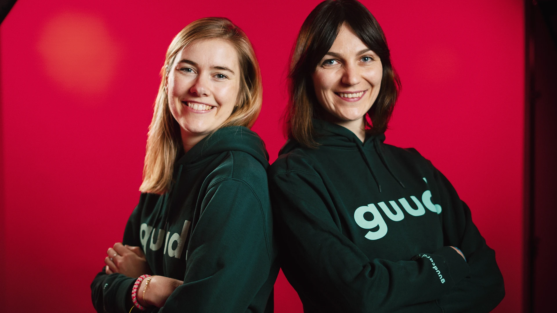 Die Gründerinnen von guud stehen Rücken an Rücken und lächeln.