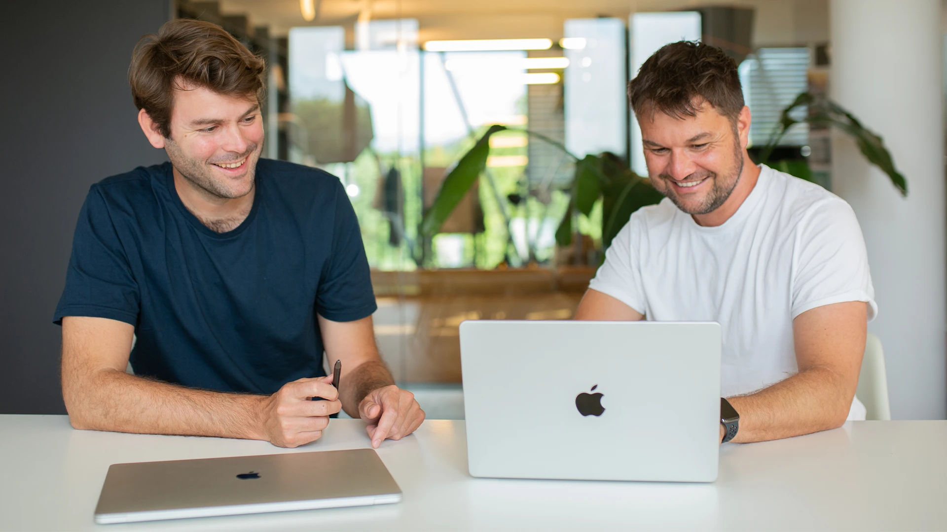 Benedikt und Leo sitzen am Tisch vor einem Laptop