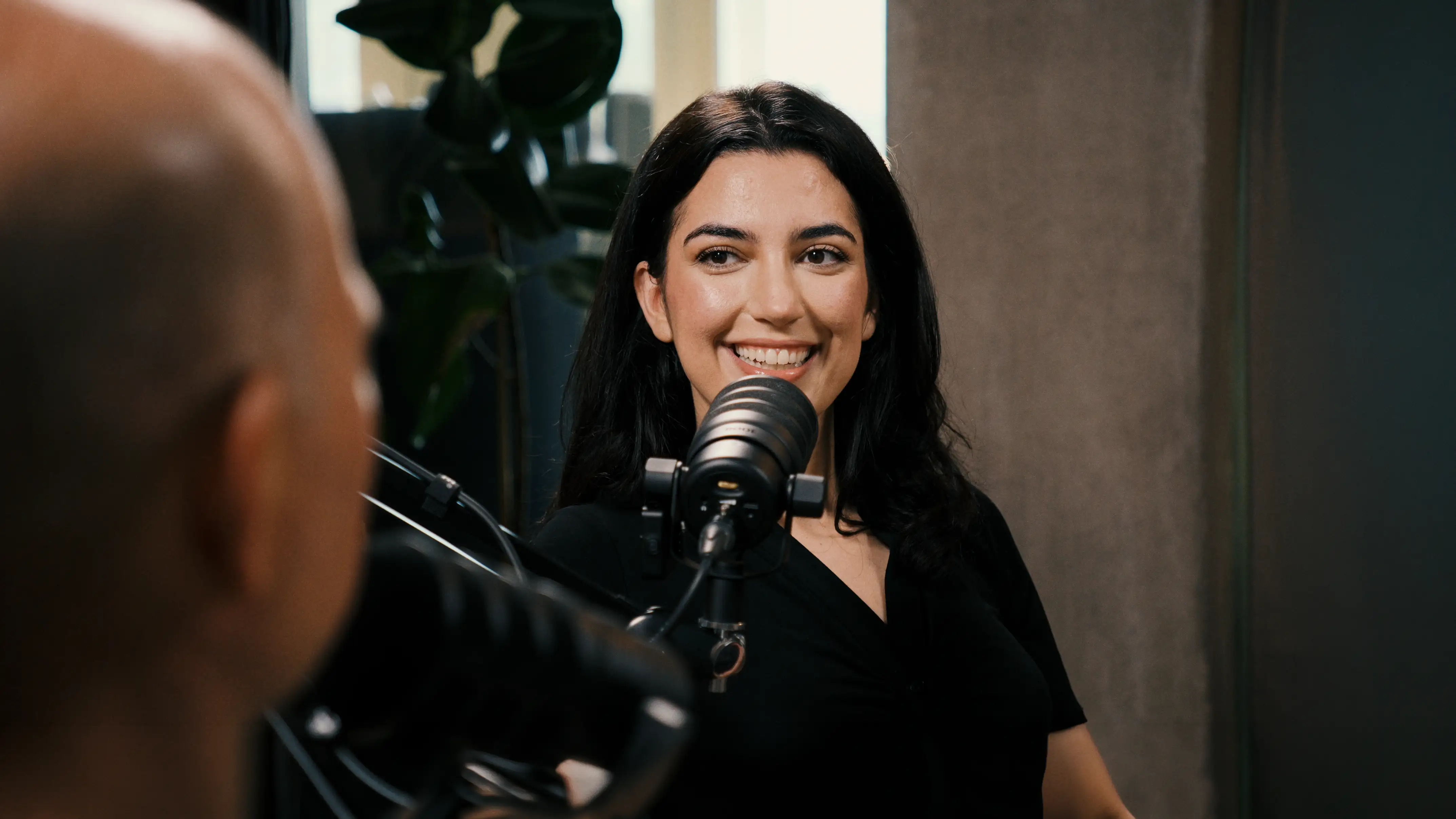 Aya Jaff lächelt im Podcaststudio