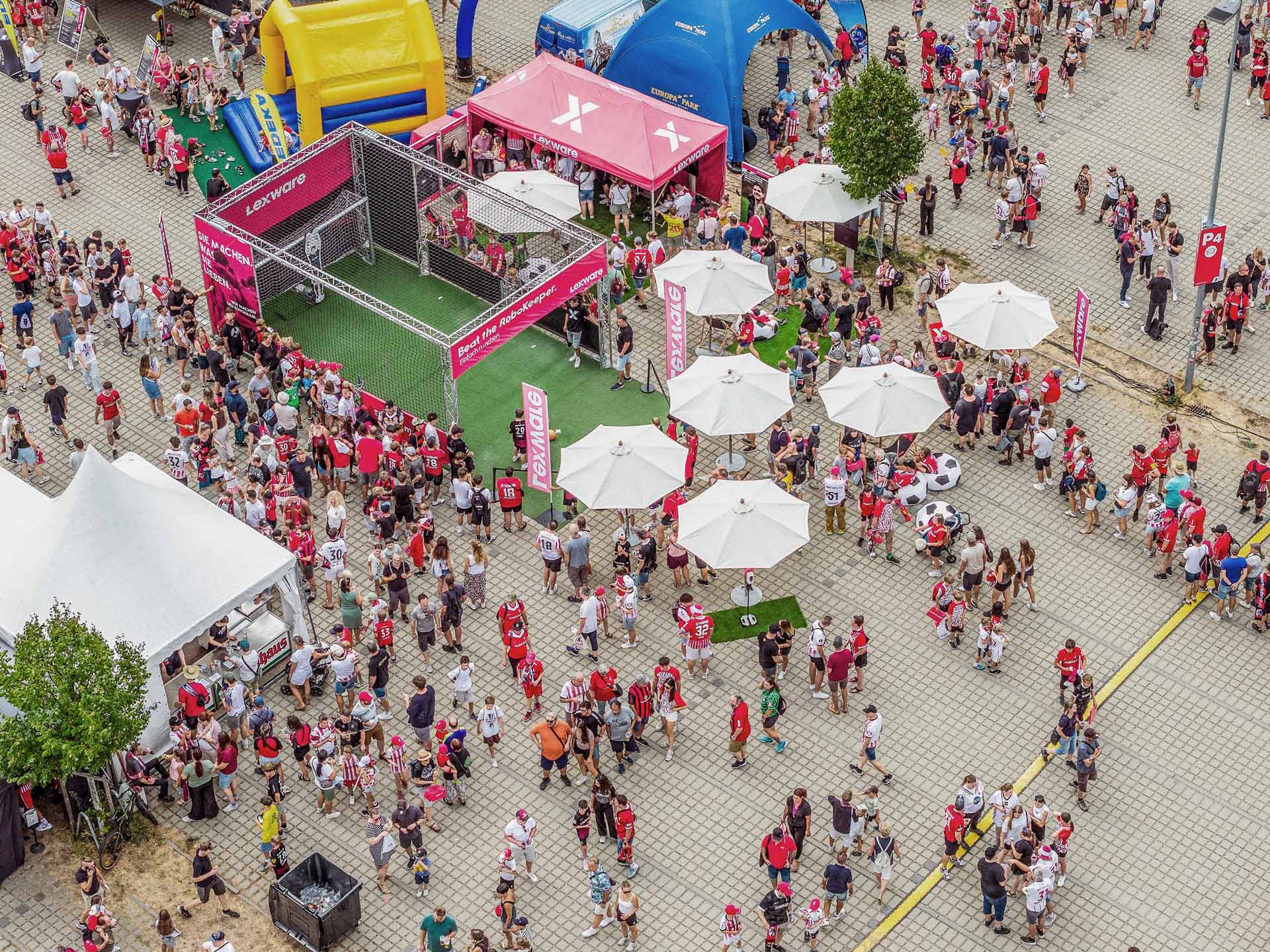 Fanzone vor dem Europa-Park Stadion zur Saisoneröffnung mit Lexware-Bandenwerbung und SC-Freiburg-Fans in der Warteschlange