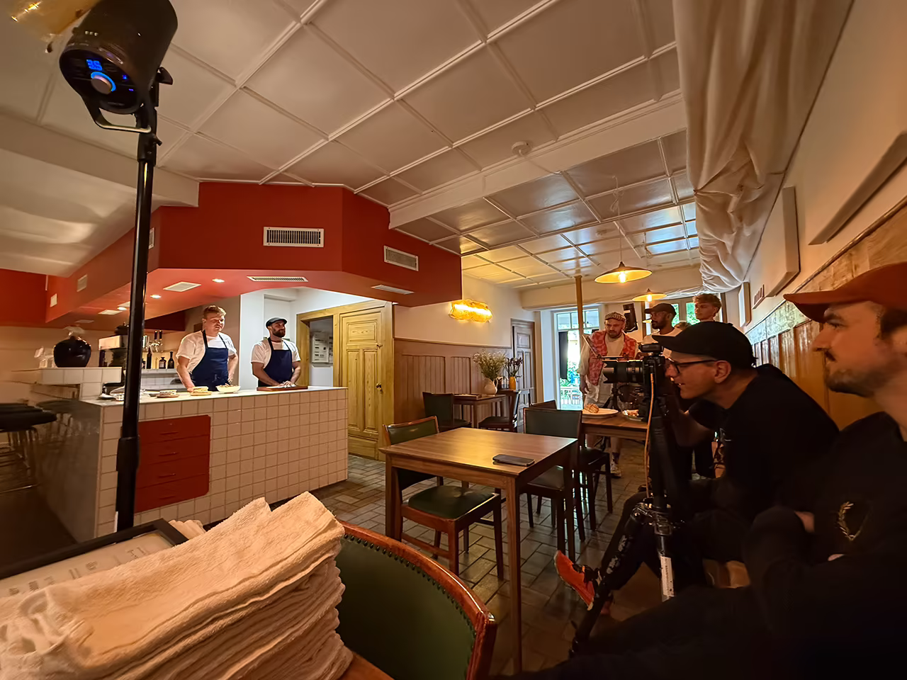 Christoph Duepper fotografiert vom Stativ aus zwei Köche hinter einem Restaurantcounter.