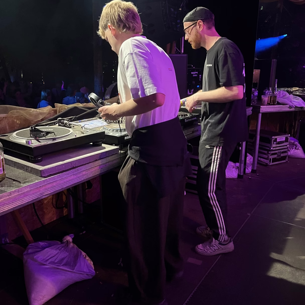 Martin Meyer legt gemeinsam mit Philipp Höne an Plattenspielern auf, die Bühne ist lila beleuchtet.