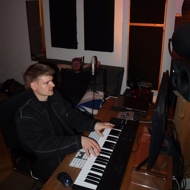 Martin Meyer spielt im Studio auf einem Keyboard, im Hintergrund sitzt eine zweite Person auf dem Sofa.